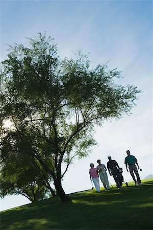 Silhouettes of group of golfers walking on golf course Stock Photo - Premium Royalty-Free, Code: 693-03707006