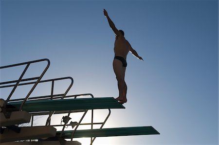 Swimmer standing on diving board at sunset Stock Photo - Premium Royalty-Free, Code: 693-03707069