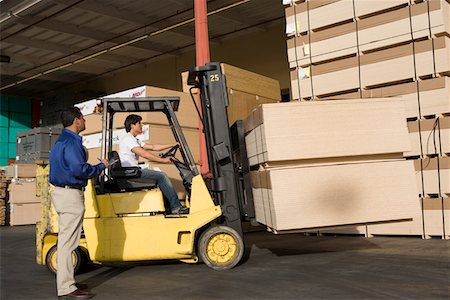 Warehouseman and forklift truck driver Stock Photo - Premium Royalty-Free, Code: 693-03707099