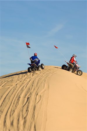 quad biking - Young Men Riding ATVs Over Sand Dunes Stock Photo - Premium Royalty-Free, Code: 693-03707118