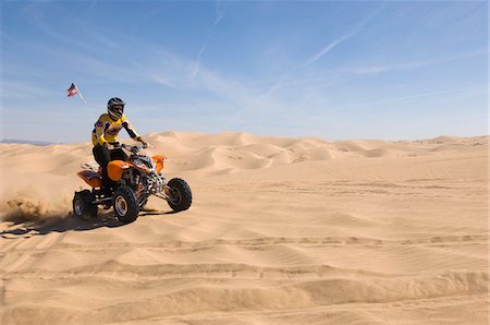 quad biking - Young Man Riding ATV Over Sand Dune Stock Photo - Premium Royalty-Free, Code: 693-03707111