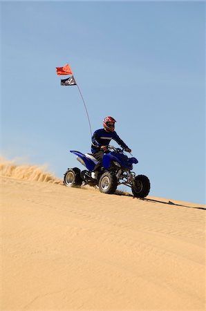 quad biking - Young Man Riding ATV Over Sand Dune Stock Photo - Premium Royalty-Free, Code: 693-03707113