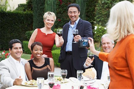 simsearch:693-06015925,k - Woman photographing friends celebrating with food and drink in garden Stock Photo - Premium Royalty-Free, Code: 693-03707132