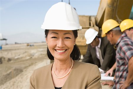 Female surveyor and construction workers on site, portrait Stock Photo - Premium Royalty-Free, Code: 693-03707180
