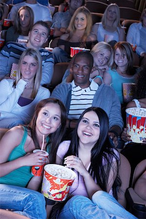 Young women sharing popcorn, Watching Movie Together Foto de stock - Sin royalties Premium, Código: 693-03707200