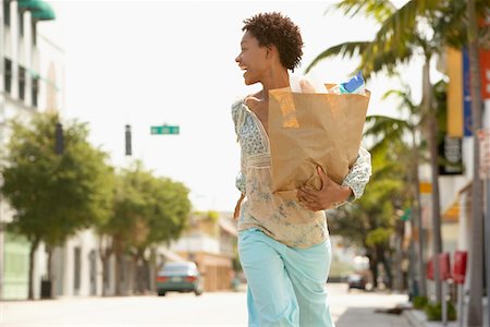 Woman carrying grocery bag while walking, profile Foto de stock - Sin royalties Premium, Código: 693-03707375