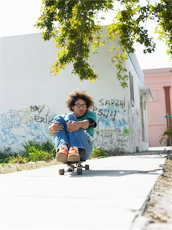 simsearch:400-05260723,k - Young man sitting on skateboard, outdoors Foto de stock - Sin royalties Premium, Código: 693-03707420