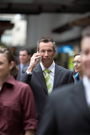 Businessman using mobile phone among crowd in station Stock Photo - Premium Royalty-Free, Code: 693-03707486