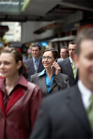 Businesswoman using mobile phone among crowd in station Stock Photo - Premium Royalty-Free, Code: 693-03707487