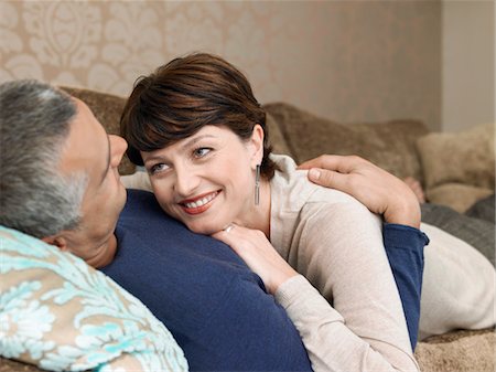 Smiling couple relaxing on sofa in living room Stock Photo - Premium Royalty-Free, Code: 693-03707490