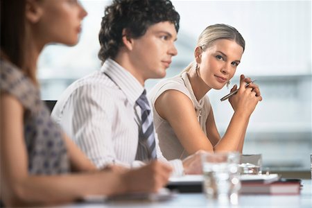 Three businesspeople sitting at business meeting Stock Photo - Premium Royalty-Free, Code: 693-03707727