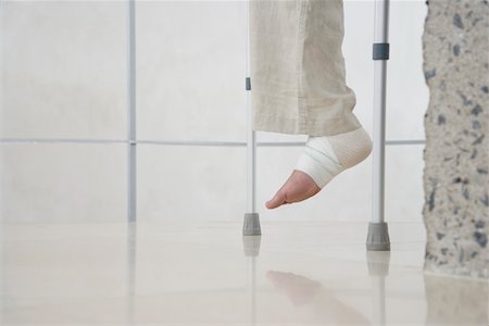 slogatura - Human foot of person on crutches, low section Fotografie stock - Premium Royalty-Free, Codice: 693-03707744