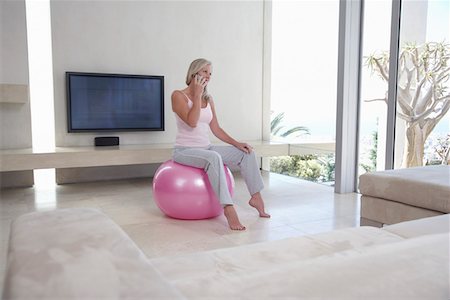 fitness   mature woman - Mature woman sitting on exercise ball in living room, talking on phone Stock Photo - Premium Royalty-Free, Code: 693-03707747