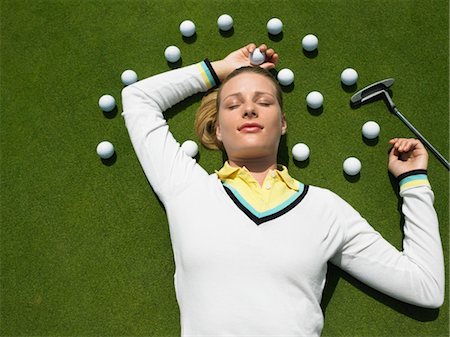 Woman Lying on Putting Green with Golf Balls Foto de stock - Sin royalties Premium, Código: 693-03707752