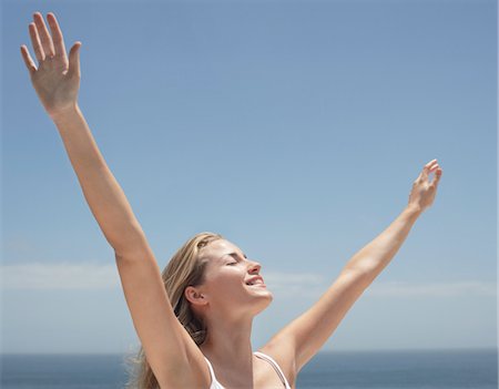 simsearch:693-03312809,k - Young woman with arms outstretched and eyes closed on beach Foto de stock - Sin royalties Premium, Código: 693-03707842