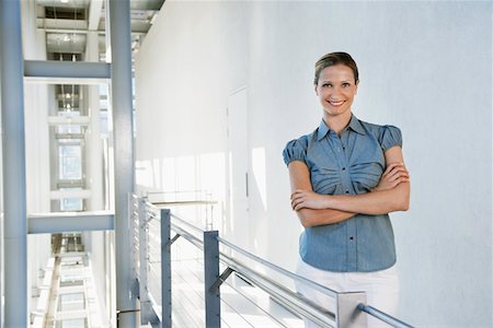 simsearch:693-03707560,k - Businesswoman smiling in office building, portrait Fotografie stock - Premium Royalty-Free, Codice: 693-03707857