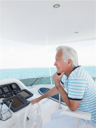 Middle-aged man sitting at helm of yacht, side view Foto de stock - Sin royalties Premium, Código: 693-03707947