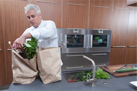 servicio de banquetes - Mid- adult chef unpacking groceries Foto de stock - Sin royalties Premium, Código: 693-03782508