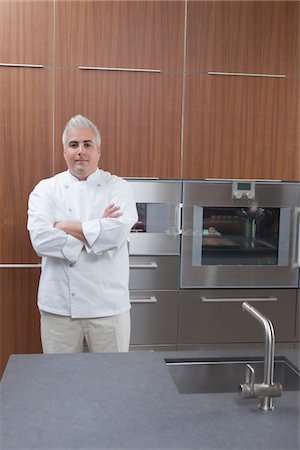 simsearch:6109-08489042,k - Mid- adult chef stands with arms folded Foto de stock - Sin royalties Premium, Código: 693-03782501