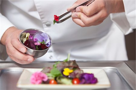 Mid- adult chef arranges edible flowers on salad Foto de stock - Sin royalties Premium, Código: 693-03782538