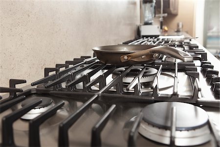 stainless steel stove top - Frying pan on hob Stock Photo - Premium Royalty-Free, Code: 693-03782554