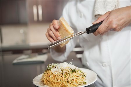 Râper le parmesan sur les spaghettis Photographie de stock - Premium Libres de Droits, Code: 693-03782572