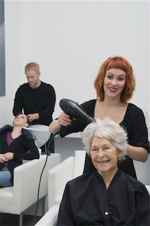 relationship of hairdresser to client - Stylist blow-drys elderly woman's hair Stock Photo - Premium Royalty-Free, Code: 693-03782594