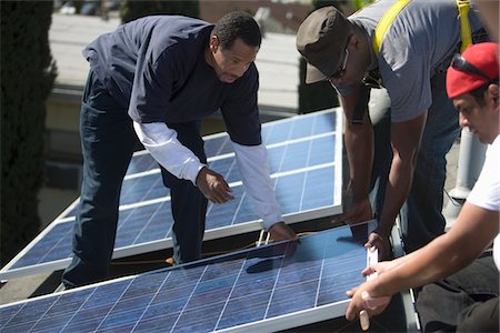 photovoltaique - Un groupe d'hommes soulevant un grand panneau solaire Photographie de stock - Premium Libres de Droits, Code: 693-03782682