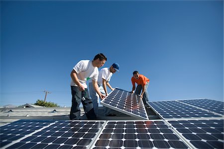 solar panel roof - A group of men lifting a large solar panel Stock Photo - Premium Royalty-Free, Code: 693-03782683