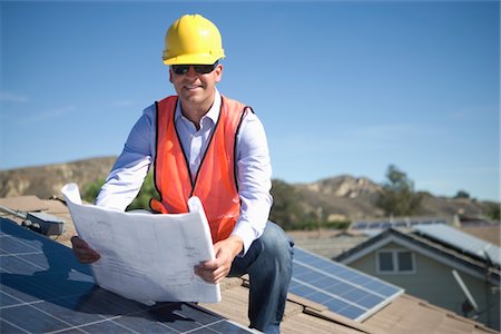 solar - Ein Business-Mann auf einem solar Panalled-Dach, die Pläne zu betrachten Stockbilder - Premium RF Lizenzfrei, Bildnummer: 693-03782694