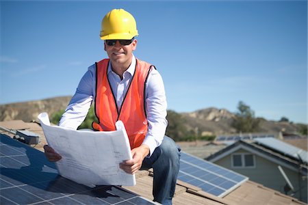 photovoltaique - Un homme d'affaires sur un toit solaire panalled regardant des plans Photographie de stock - Premium Libres de Droits, Code: 693-03782694