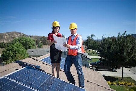 solaire - Deux hommes d'affaires sur un toit à côté de solaire panneaux, brandissant un ensemble de plans Photographie de stock - Premium Libres de Droits, Code: 693-03782695