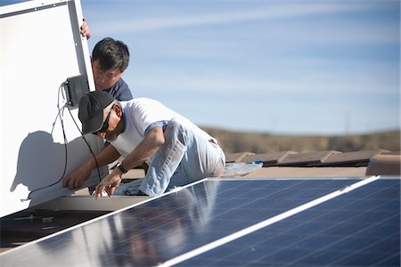 photovoltaique - Deux personnes sur le toit d'un travail sur l'énergie solaire panneaux Photographie de stock - Premium Libres de Droits, Code: 693-03782699