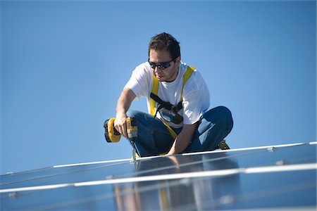 solaire - Un homme travaillant sur des panneaux solaire Photographie de stock - Premium Libres de Droits, Code: 693-03782690