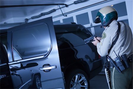 Patrouilleur de veilleur de nuit, stand off avec voiture de luxe dans le garage Photographie de stock - Premium Libres de Droits, Code: 693-03782786