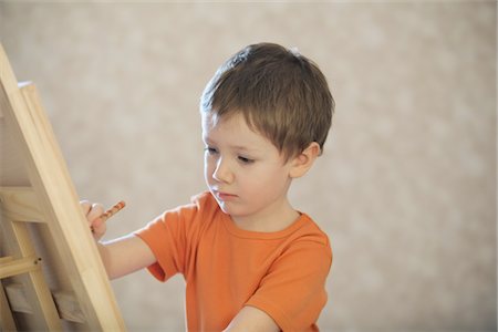 drawings - A young boy drawing onto a canvas Stock Photo - Premium Royalty-Free, Code: 693-03782882