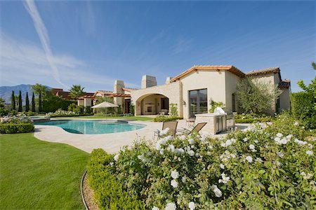 House exterior in daylight with a garden,plants,a swimming pool and hills in the far distance Foto de stock - Sin royalties Premium, Código: 693-03782929