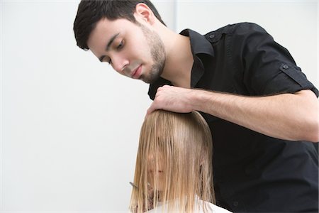 Man cutting a young womans hair in the hairdressers Stock Photo - Premium Royalty-Free, Code: 693-03783007