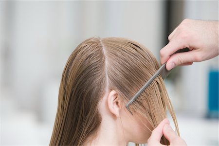 Combing a womans wet hair in the hairdressers Foto de stock - Royalty Free Premium, Número: 693-03783000