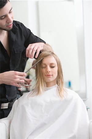 Man cutting a young womans hair in the hairdressers Foto de stock - Royalty Free Premium, Número: 693-03783010