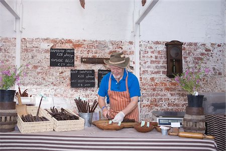 delicatessen - Mature man prepares speciality sausages Stock Photo - Premium Royalty-Free, Code: 693-03783159