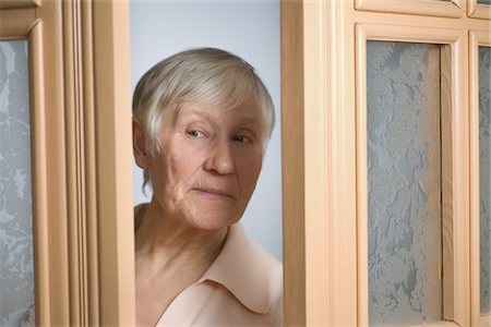 prudenza - Elderly woman with short grey hair opening front door Fotografie stock - Premium Royalty-Free, Codice: 693-03783174