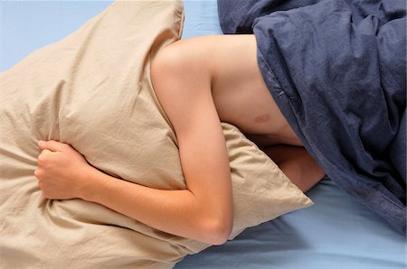 Teenage Boy in Bed Hiding Face with Pillow Foto de stock - Con derechos protegidos, Código: 700-04929260