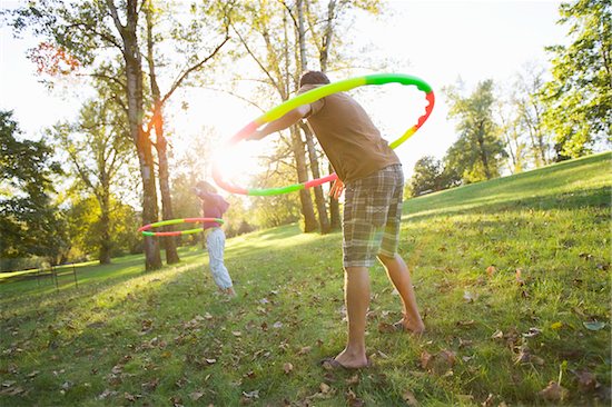 Two People Playing with Hula Hoops in Park Stock Photo - Premium Rights-Managed, Artist: Ty Milford, Image code: 700-04931697