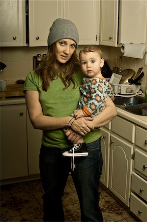 parent and child concern - Mother Holding Son in Messy Kitchen Stock Photo - Rights-Managed, Code: 700-04981807