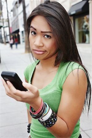 Unimpressed Woman Holding Cell Phone Foto de stock - Con derechos protegidos, Código: 700-05451006