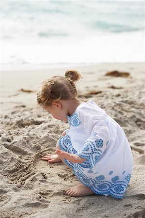 Fillette jouant dans le sable sur la plage Photographie de stock - Rights-Managed, Code: 700-05560269