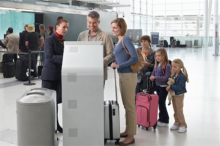 Employés de l'aéroport aidant famille arrivée à l'aéroport Photographie de stock - Rights-Managed, Code: 700-05756419