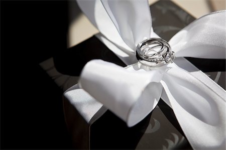 présent - Anneaux de mariage sur l'arc de Satin blanc Photographie de stock - Rights-Managed, Code: 700-05803328