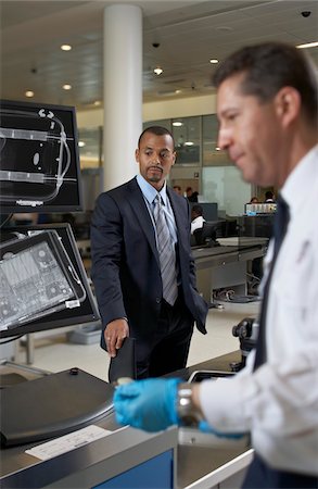 Businessman Waiting at Baggage Check in Airport Foto de stock - Direito Controlado, Número: 700-05821738